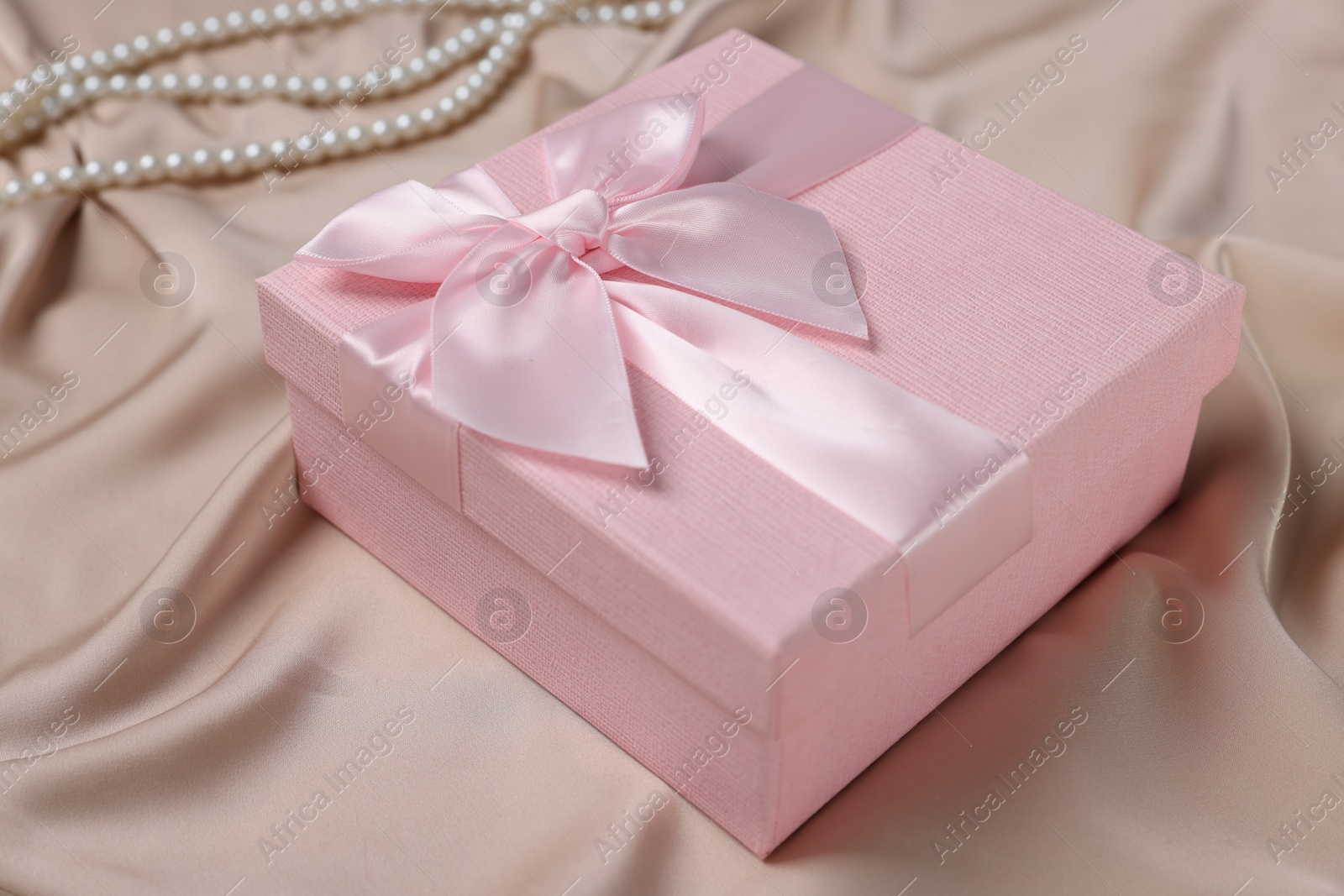 Photo of Gift box for wedding day on beige fabric, closeup