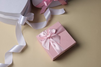 Photo of Gift boxes for wedding day on beige background, flat lay. Space for text