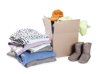 Photo of Box with different used clothes and boots isolated on white