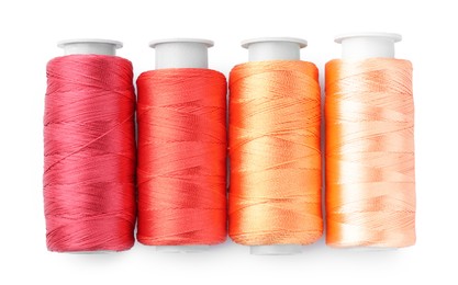 Photo of Spools of colorful sewing threads isolated on white, top view