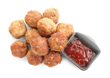 Photo of Pile of delicious meatballs and bowl with ketchup isolated on white, top view