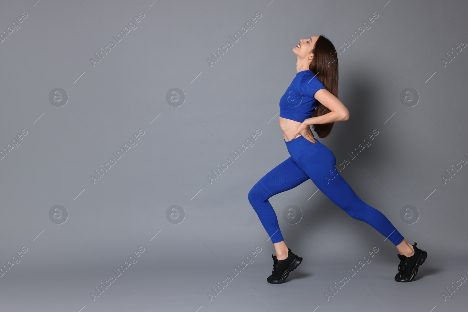 Photo of Beautiful woman in stylish sportswear on grey background