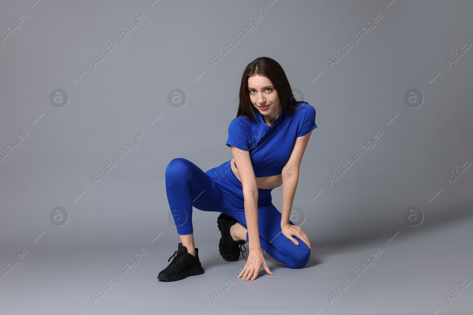 Photo of Beautiful woman in stylish sportswear on grey background