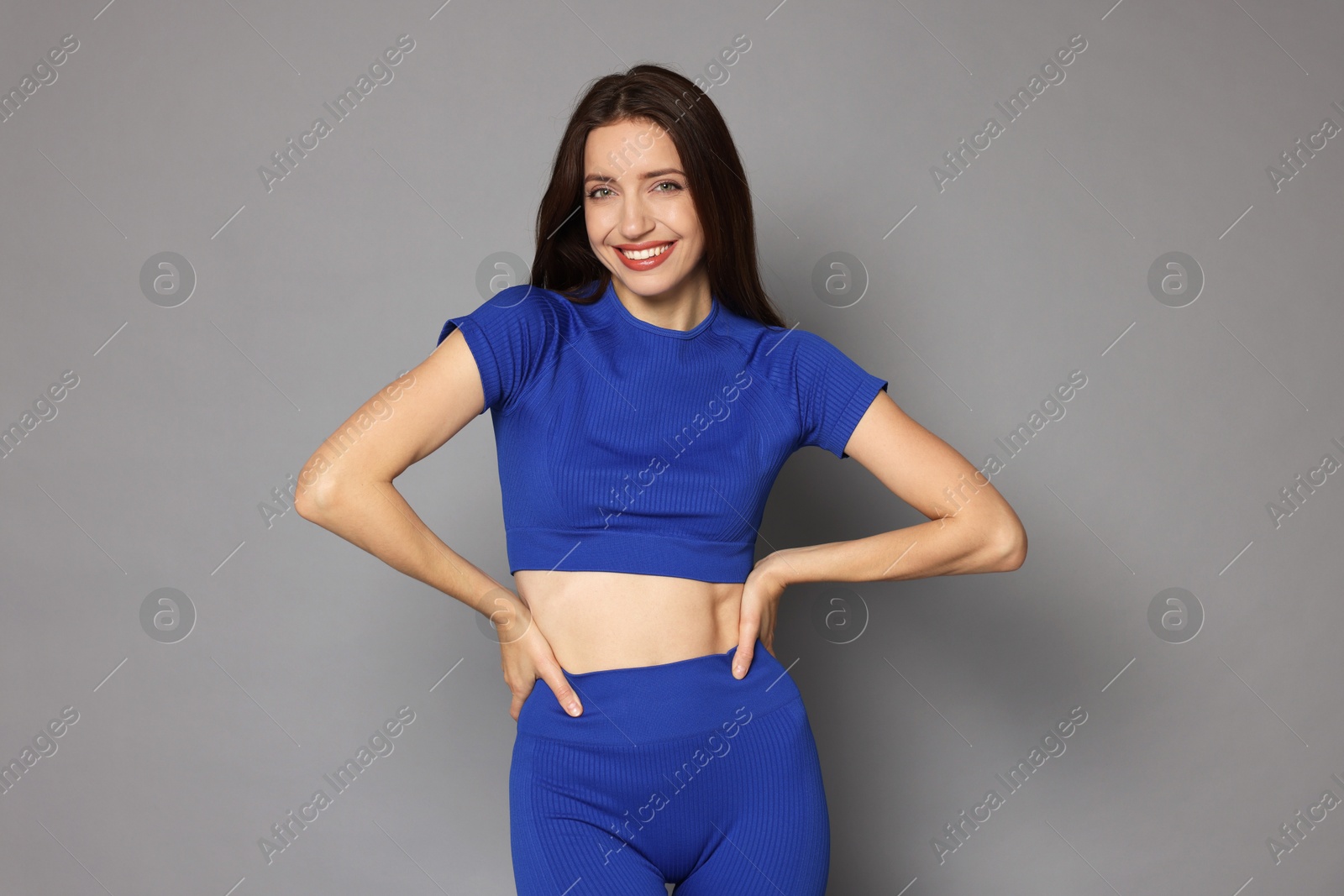 Photo of Beautiful woman in stylish sportswear on grey background