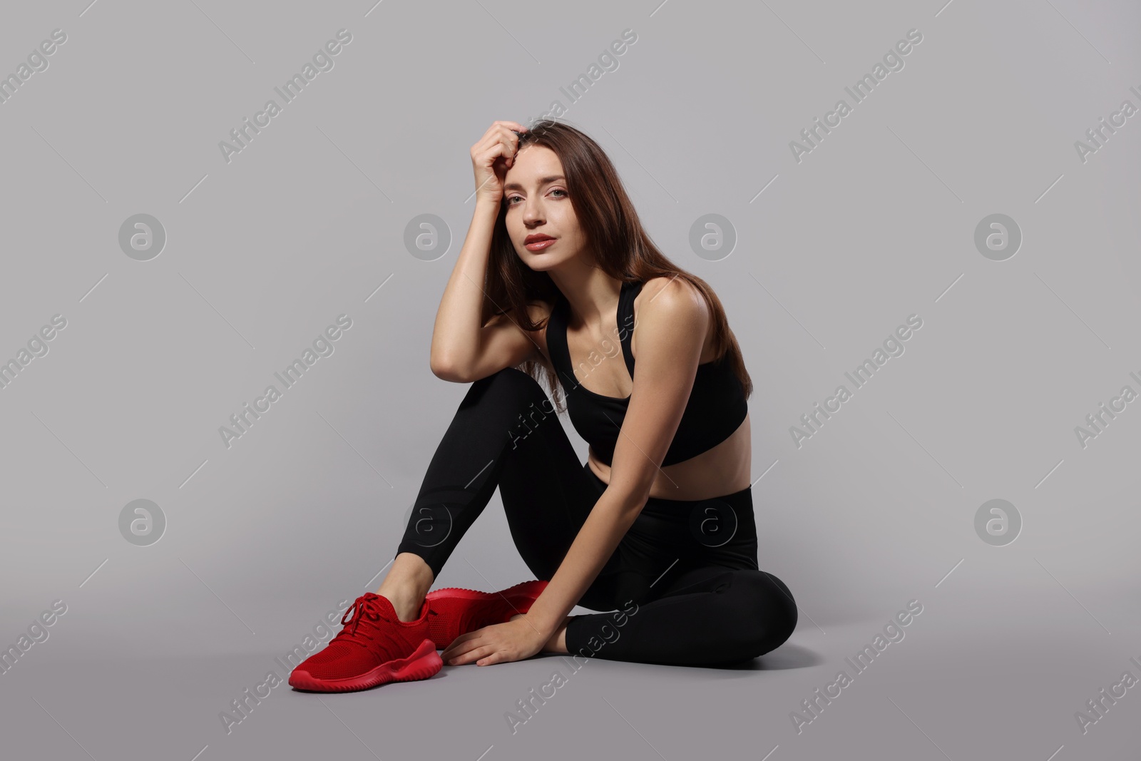 Photo of Beautiful woman in stylish sportswear on grey background