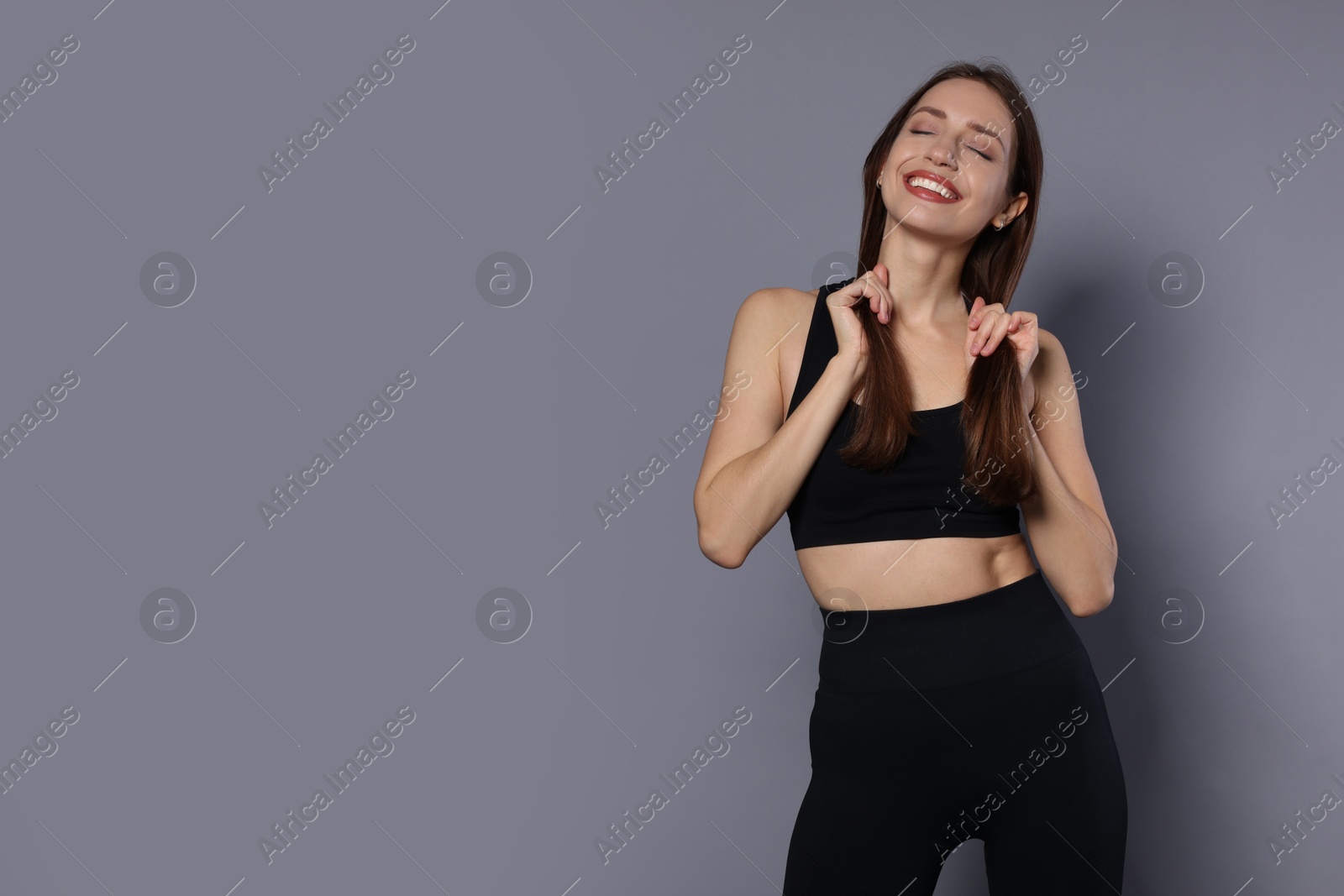 Photo of Beautiful woman in stylish sportswear on grey background. Space for text