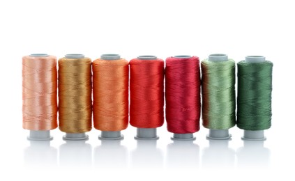 Photo of Spools of bright sewing threads isolated on white