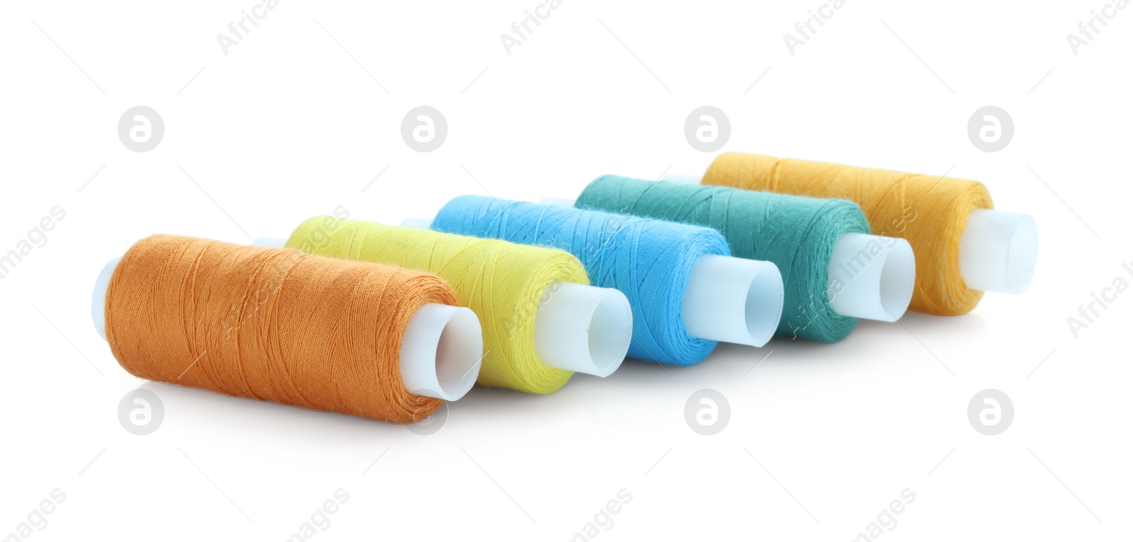 Photo of Spools of bright sewing threads isolated on white