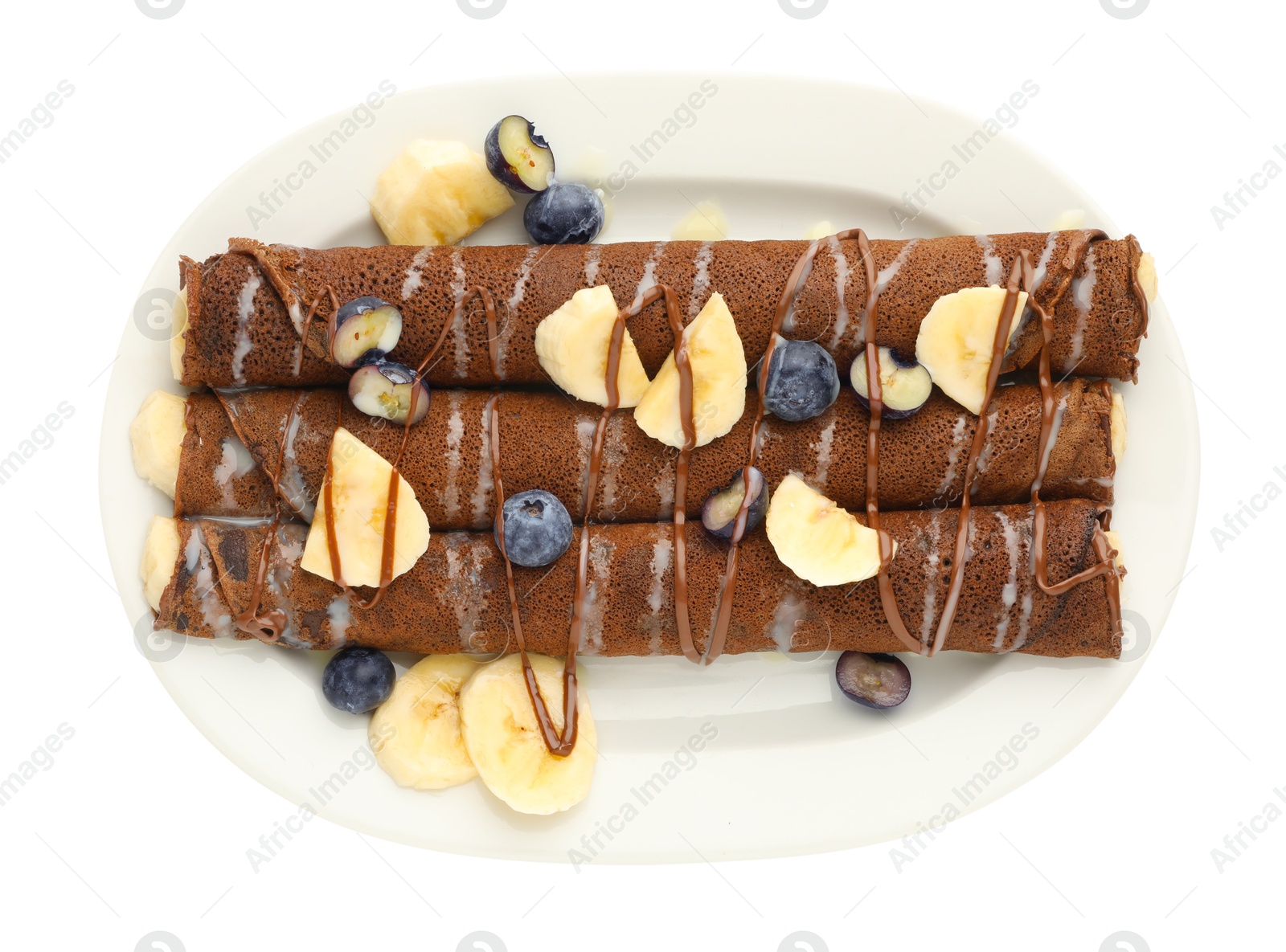 Photo of Delicious chocolate crepes with banana and blueberries isolated on white, top view