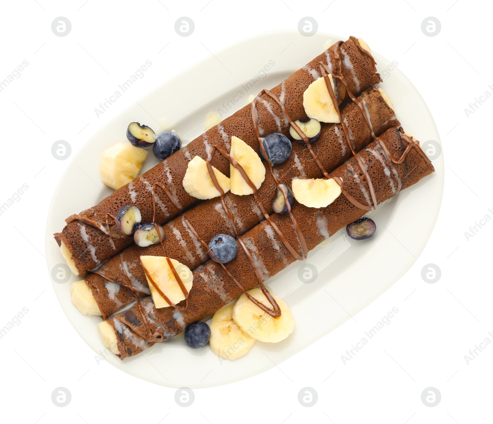 Photo of Delicious chocolate crepes with banana and blueberries isolated on white, top view