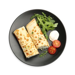 Photo of Tasty rolled crepes with cottage cheese, spinach, arugula and tomato isolated on white, top view