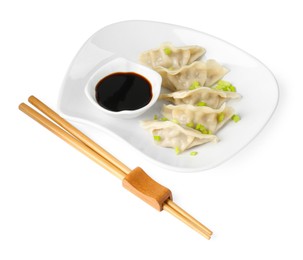 Photo of Tasty gyoza (dumplings), soy sauce and chopsticks isolated on white