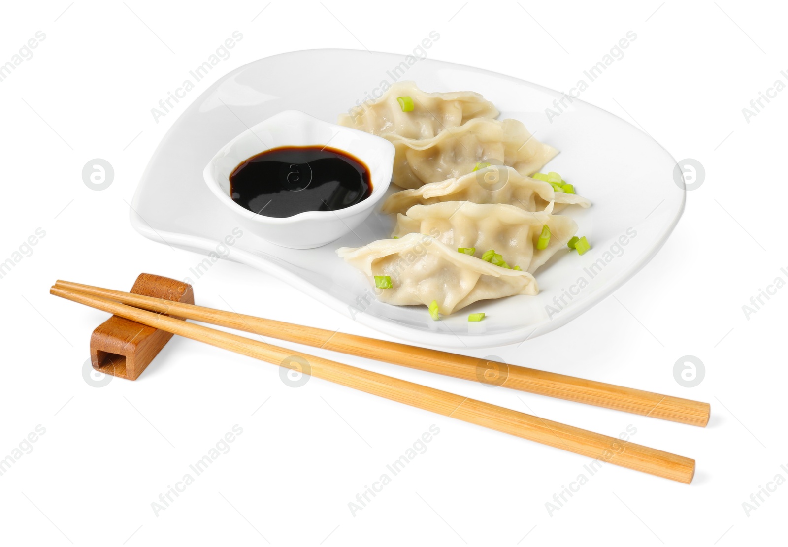 Photo of Tasty gyoza (dumplings), soy sauce and chopsticks isolated on white