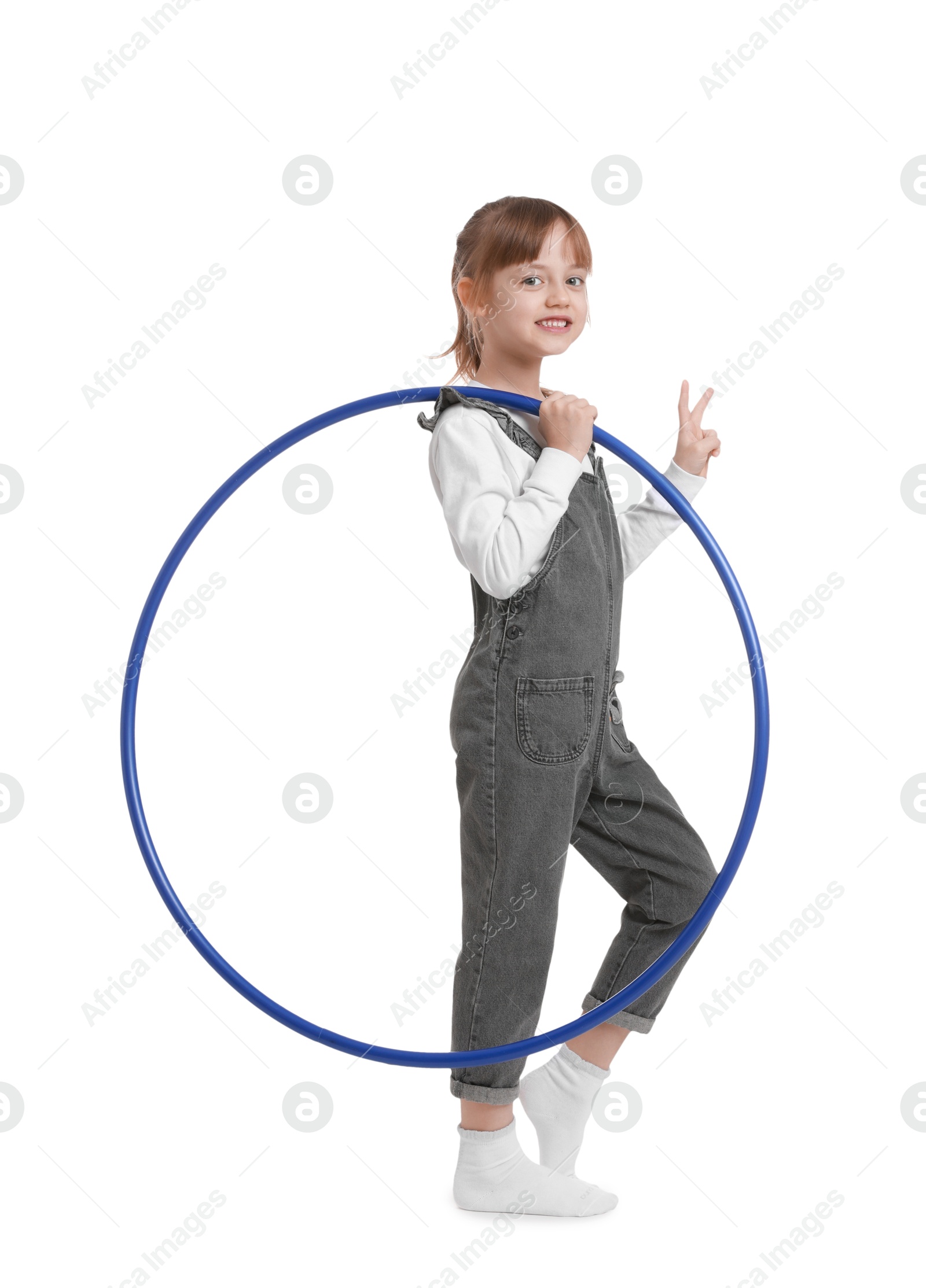 Photo of Cute little girl with hula hoop showing V-sign on white background