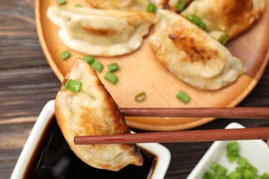 Photo of Eating fried gyoza dumplings at wooden table, top view