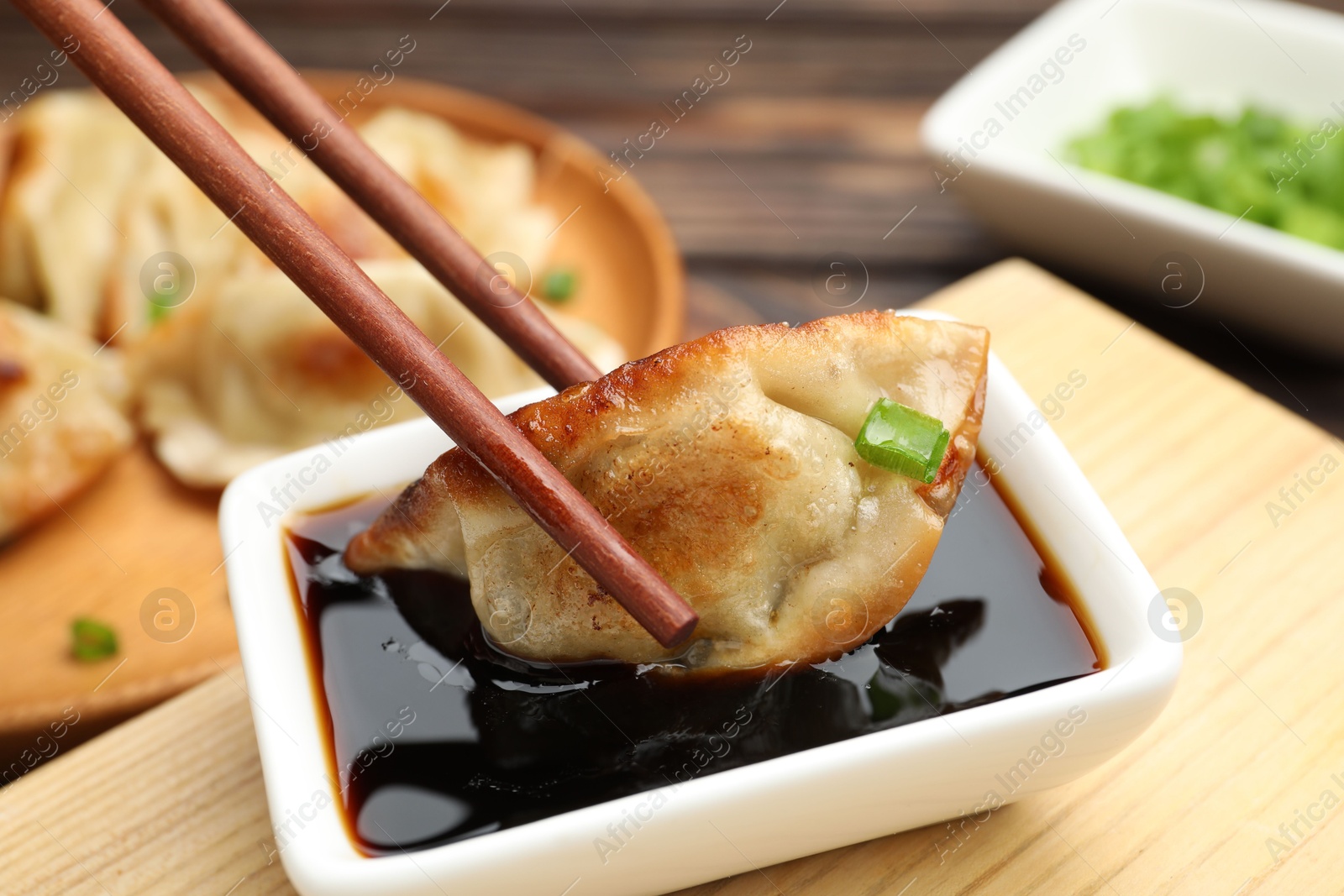 Photo of Eating fried gyoza dumplings at wooden table, closeup