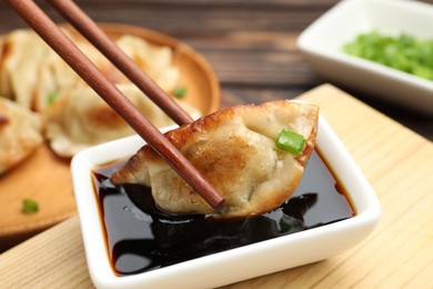 Eating fried gyoza dumplings at wooden table, closeup