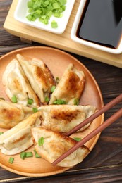 Photo of Eating fried gyoza dumplings at wooden table, top view