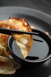 Eating fried gyoza dumplings at black table, closeup