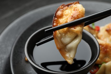 Photo of Eating fried gyoza dumplings at black table, closeup