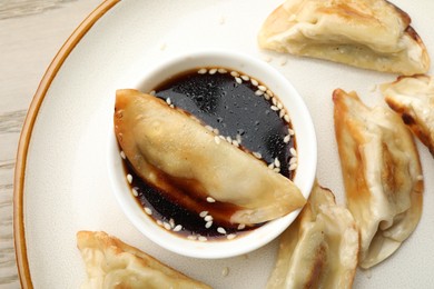 Photo of Fried gyoza dumplings with soy sauce on table, top view