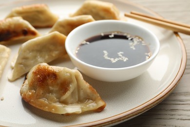 Photo of Delicious fried gyoza dumplings served on wooden table, closeup