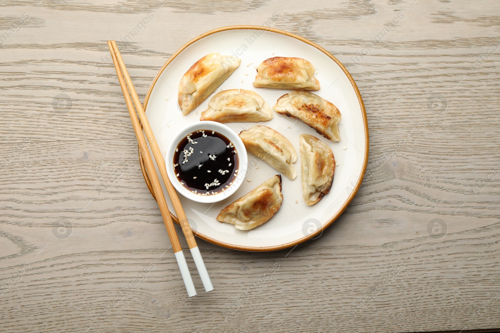 Photo of Delicious fried gyoza dumplings served on wooden table, top view