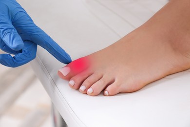 Image of Joint inflammation. Doctor checking woman's foot at hospital, closeup