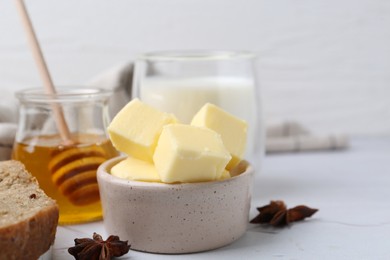 Photo of Sweet honey, butter, bread and milk on white table, closeup