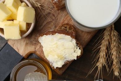 Tasty sandwich with butter, honey and milk on wooden table, flat lay