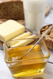 Sweet honey, butter, walnuts and milk on white wooden table, closeup