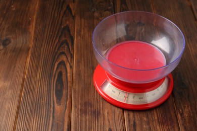 Photo of One kitchen scale on wooden table, closeup. Space for text