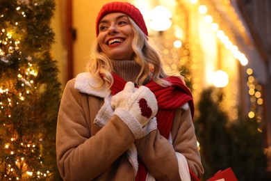 Photo of Portrait of happy woman on city street. Christmas season