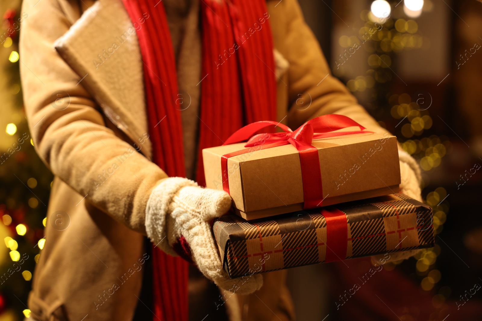 Photo of Woman with Christmas gifts on city street, closeup