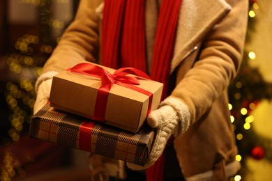 Photo of Woman with Christmas gifts on city street, closeup