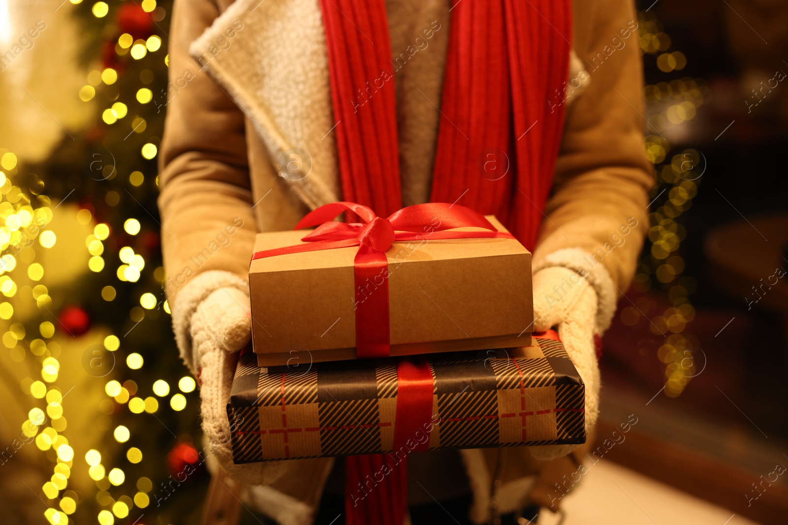 Photo of Woman with Christmas gifts on city street, closeup