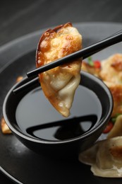 Photo of Eating fried gyoza dumplings at black table, closeup