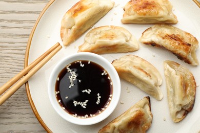 Photo of Delicious fried gyoza dumplings served on wooden table, top view