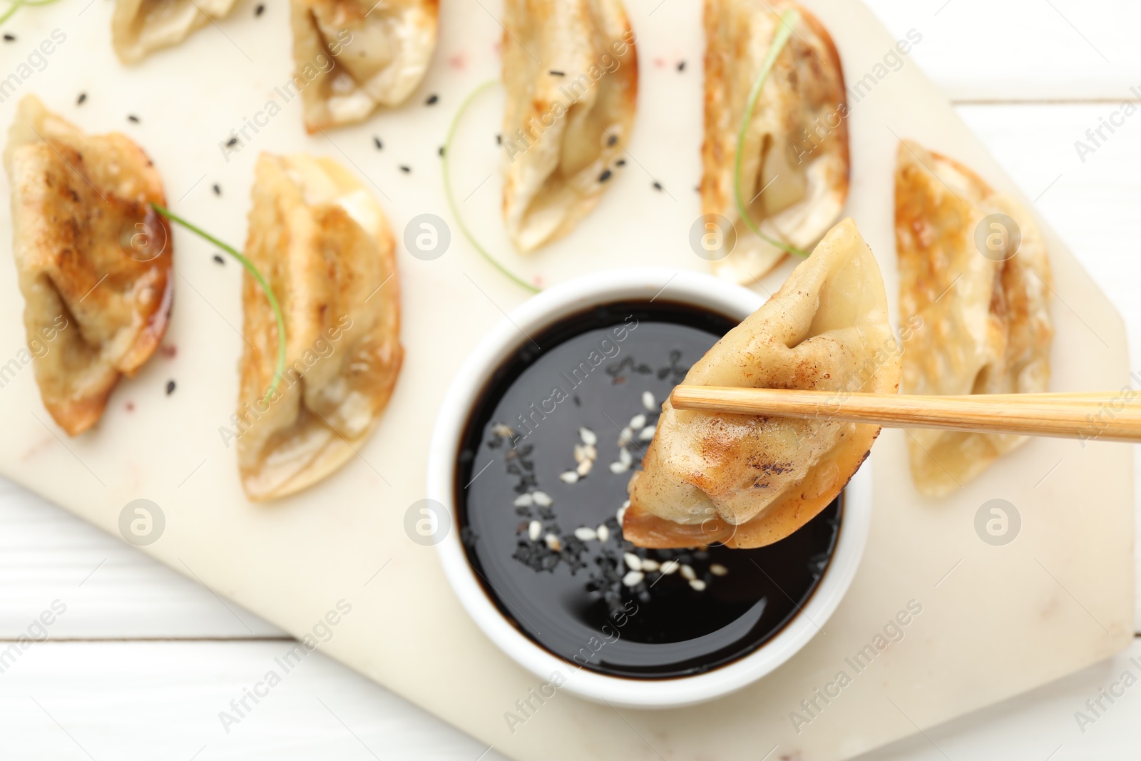 Photo of Eating fried gyoza dumplings at white wooden table, top view