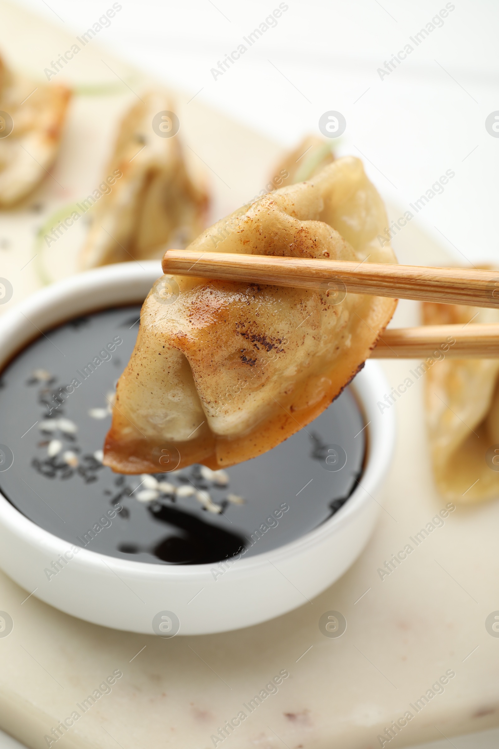 Photo of Eating fried gyoza dumplings at white table, closeup