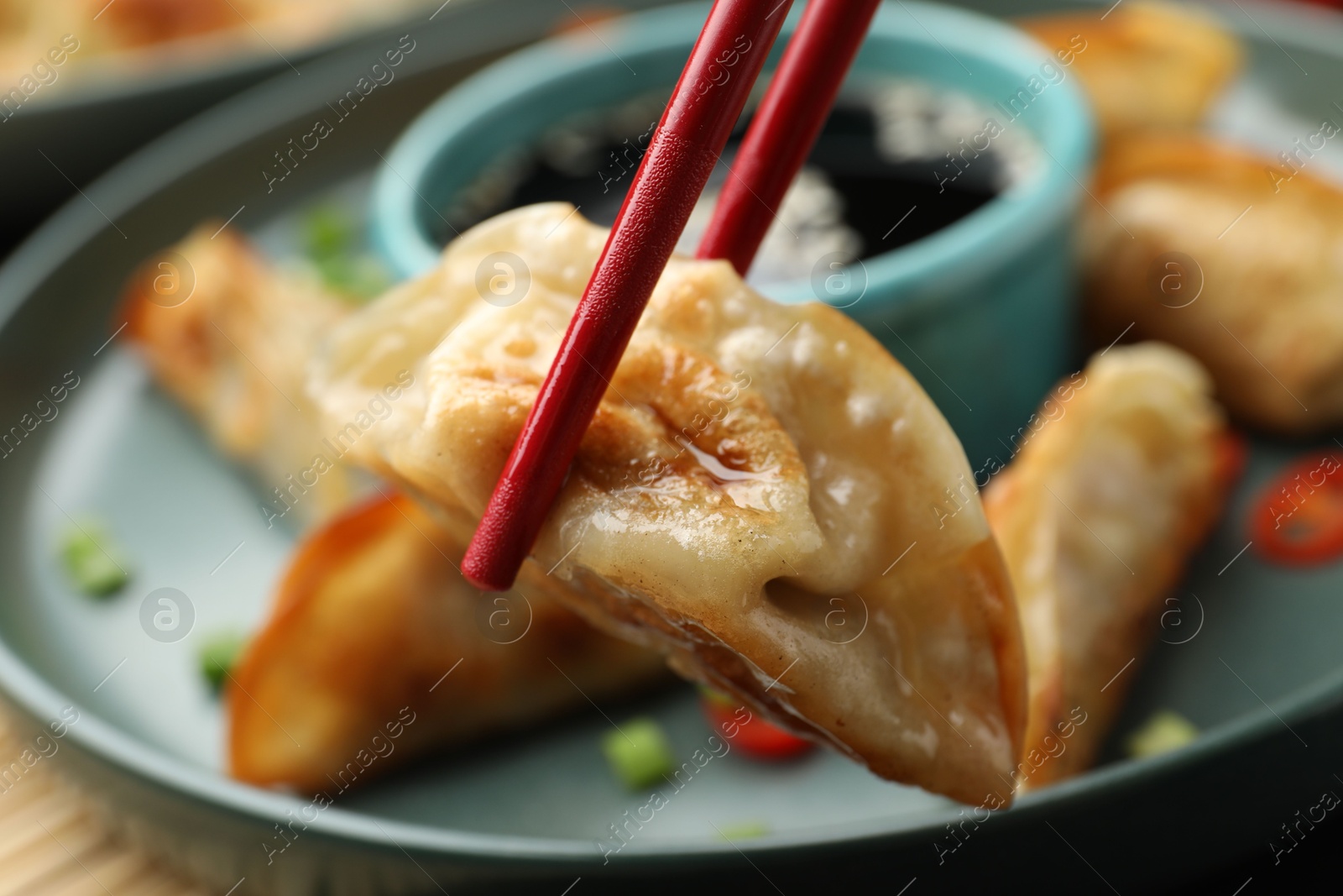 Photo of Eating fried gyoza dumplings at table, closeup