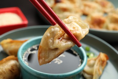 Photo of Eating fried gyoza dumplings at table, closeup