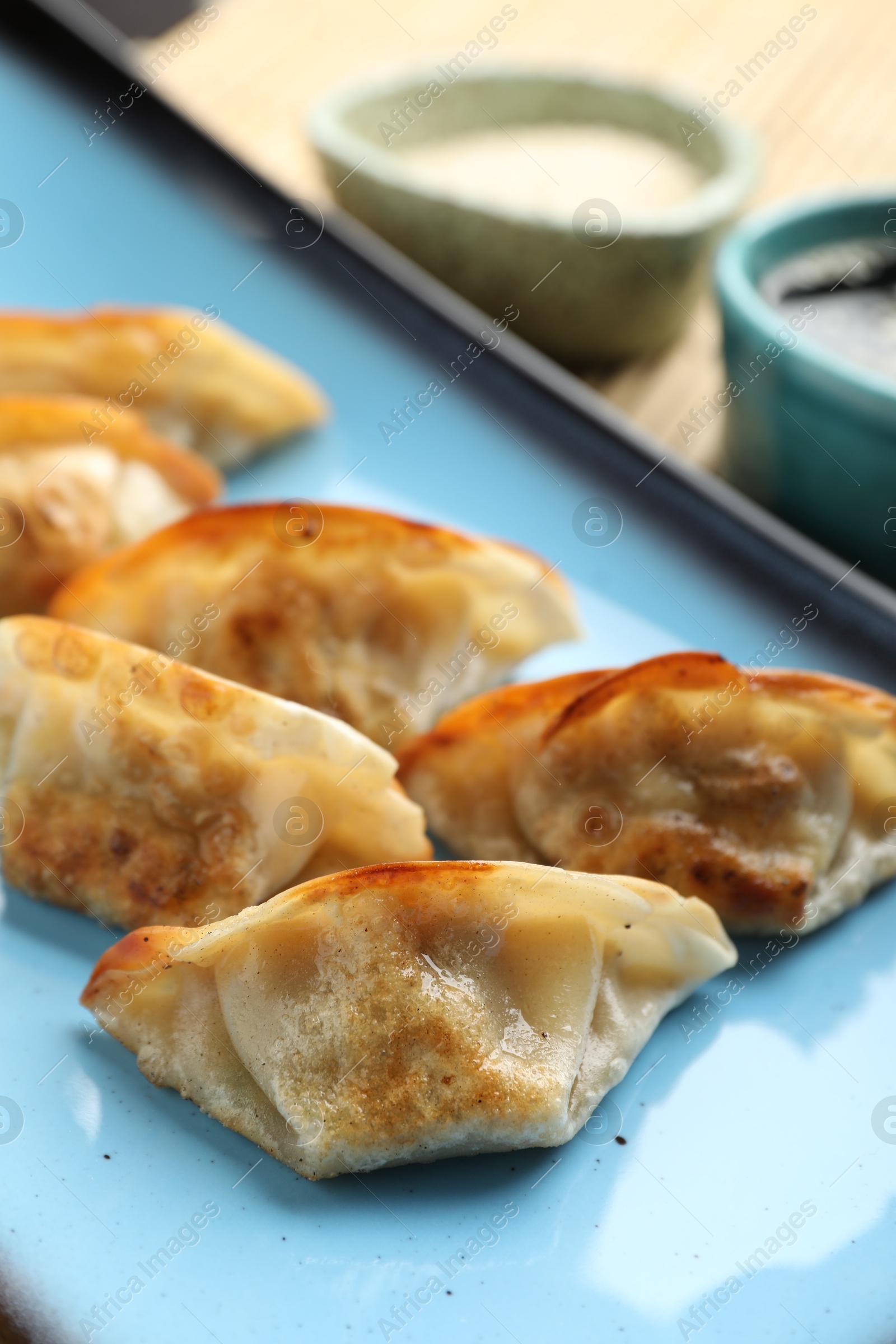 Photo of Delicious fried gyoza dumplings on table, closeup