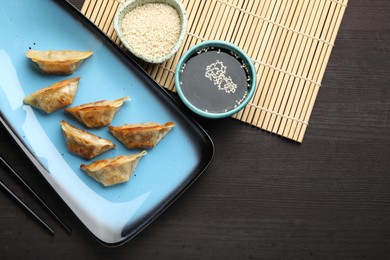 Photo of Delicious fried gyoza dumplings served on wooden table, flat lay