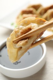 Photo of Eating fried gyoza dumplings at white table, closeup