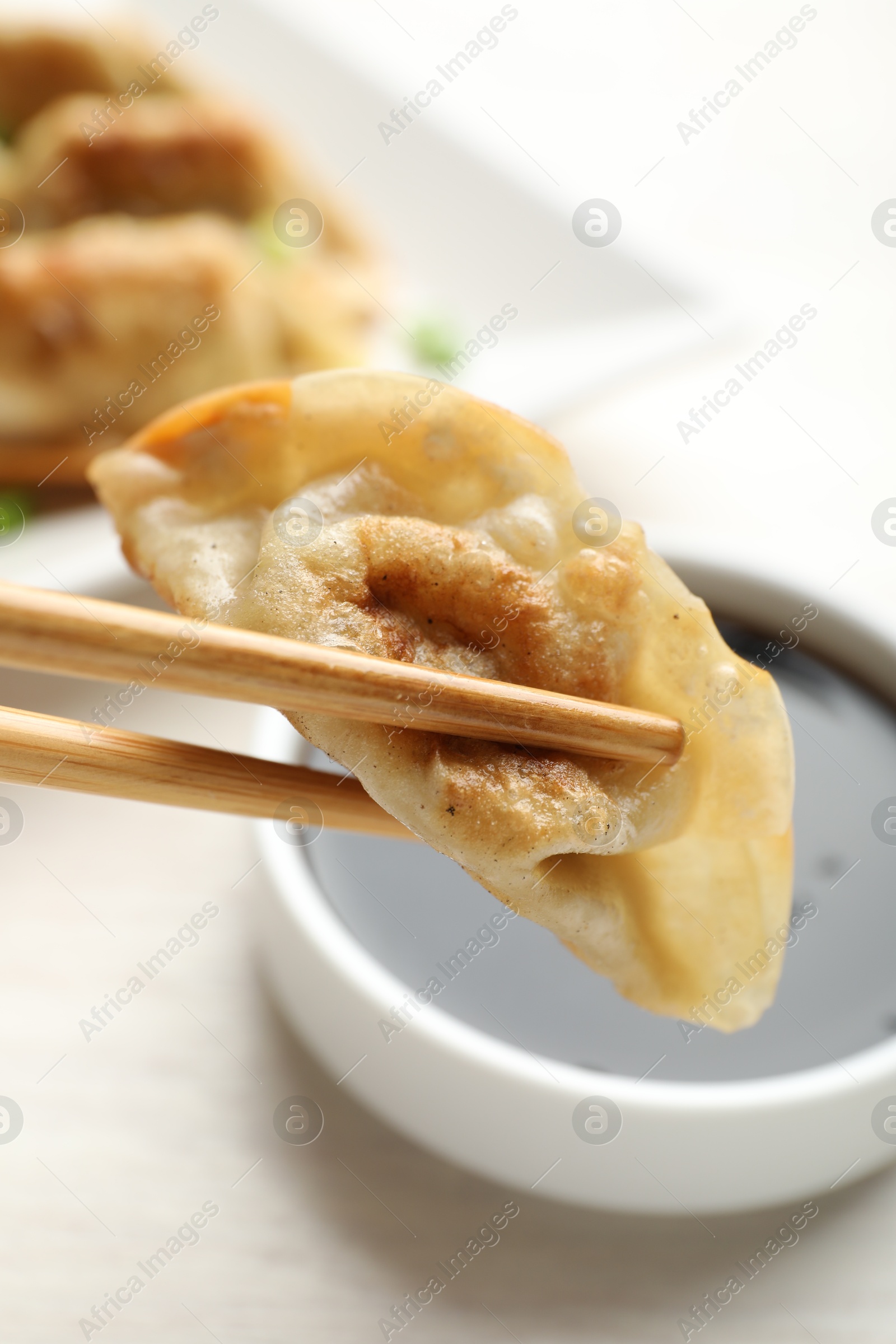 Photo of Eating fried gyoza dumplings at white table, closeup