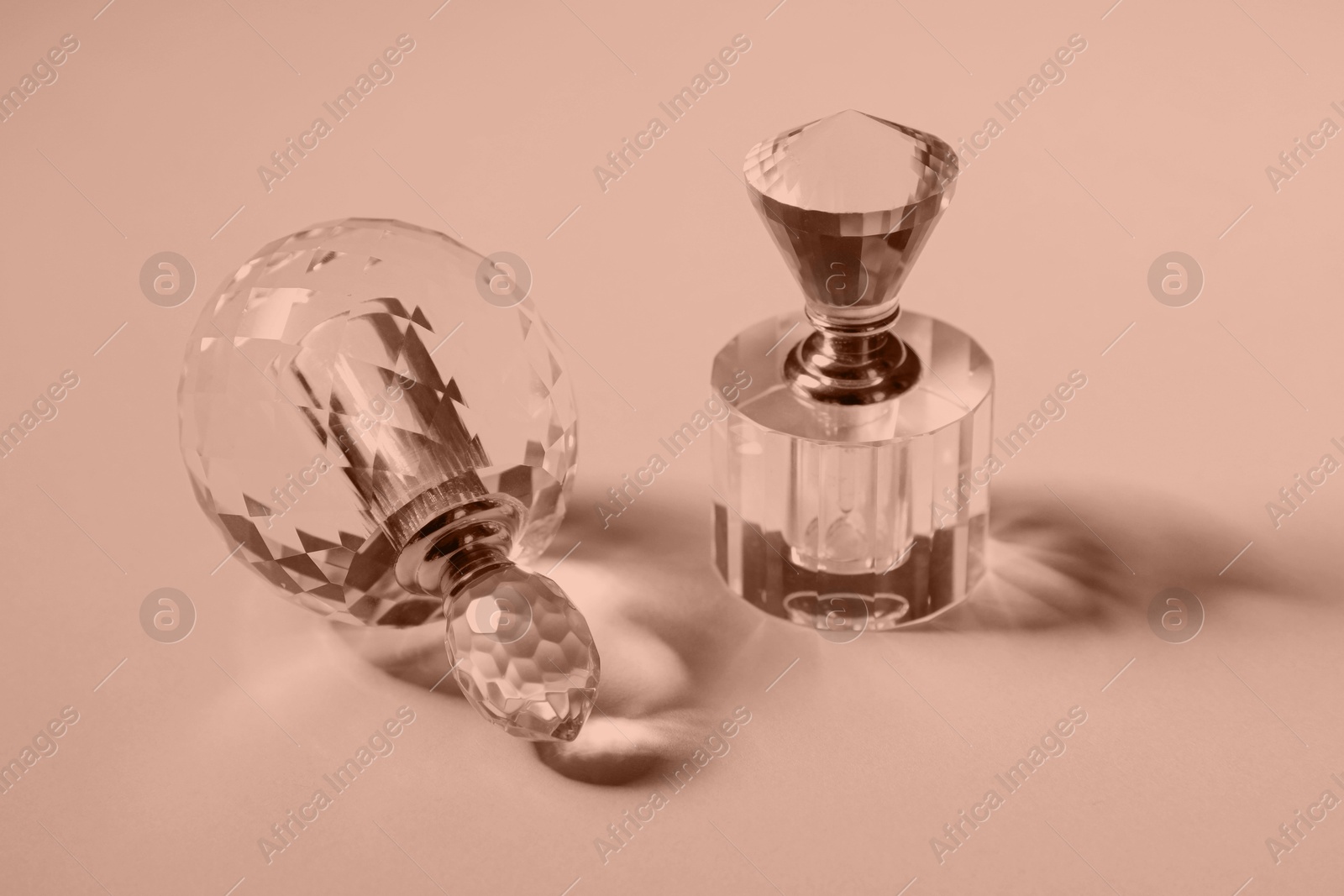 Image of Perfume bottles on color background, toned in mocha mousse shade. Color of 2025 year