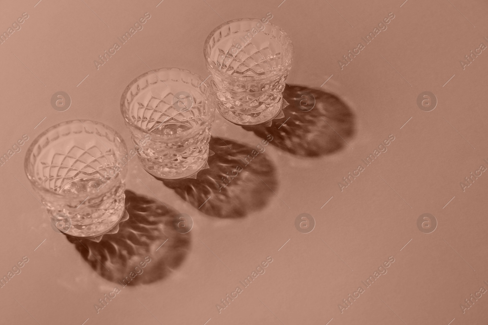 Image of Glasses on color background, toned in mocha mousse shade. Color of 2025 year