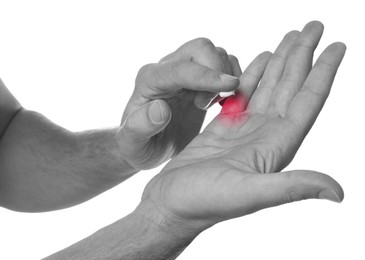 Image of Man with joint inflammation applying cream on white background, closeup. Toned in black-and-white with color area on finger