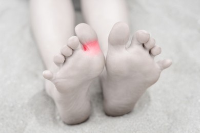 Image of Woman with joint inflammation, closeup. Highlighted area on toe. Toned in black-and-white with color area on toe